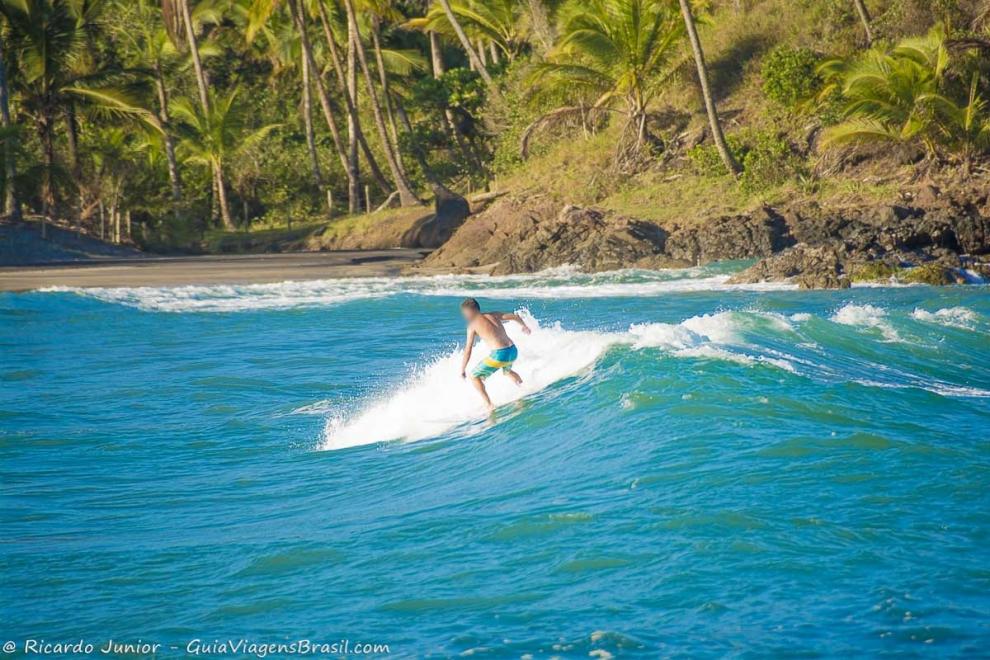 Imagem de surfista no mar azul da Prainha.